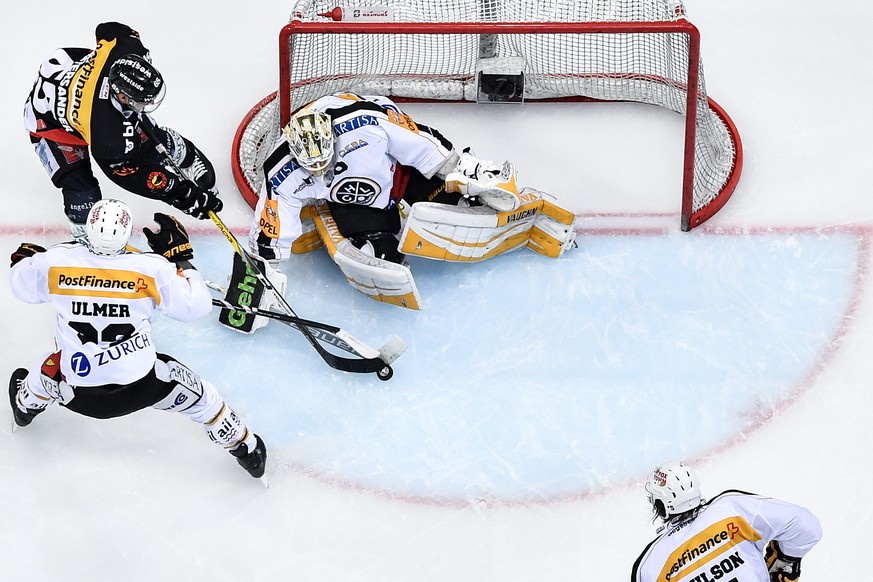 Berns Ramon Untersander, Mitte, im Duell mit Luganos Stefan Ulmer, links, und Torhueter Elvis Merzlikins im dritten Eishockey Playoff-Halbfinalspiel der National League A zwischen dem SC Bern und dem  ...