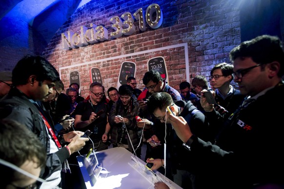 epa05816725 Visitors take a look at the new Nokia 3310 during its presentation on the eve of the opening of Mobile World Congress (MWC) in Barcelona, northeastern Spain, 26 February 2017. The congress ...