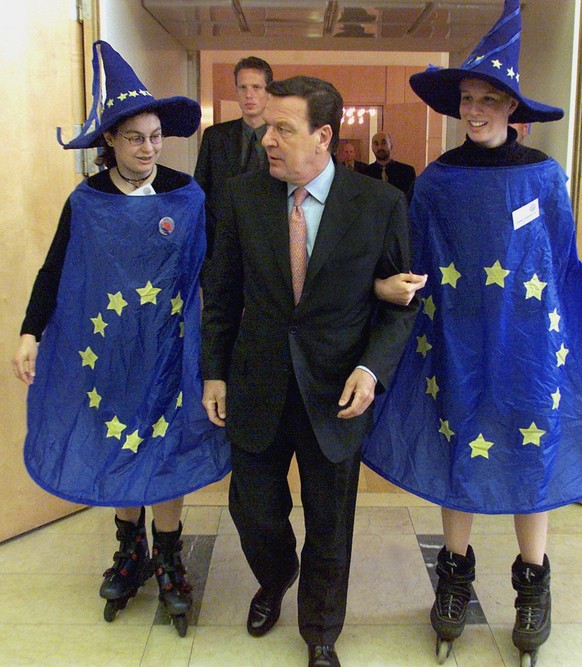 German Chancellor Gerhard Schroeder, center, is flanked by inline-skating "Euro witches" Jasmin Cam, left, and Heike Lilienbecker as he arrives for the celebrations of the "Day of Europ ...