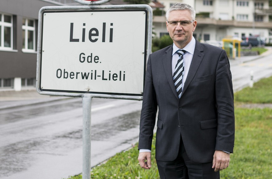 Andreas Glarner, Gemeindeammann Oberwil-Lieli, posiert eingangs Dorf Lieli vor der Ortstafel in Oberwil-Lieli, Kanton Aargau, am Mittwoch, 23. September 2015. Im Hintergrund links das Gebaeude seines  ...