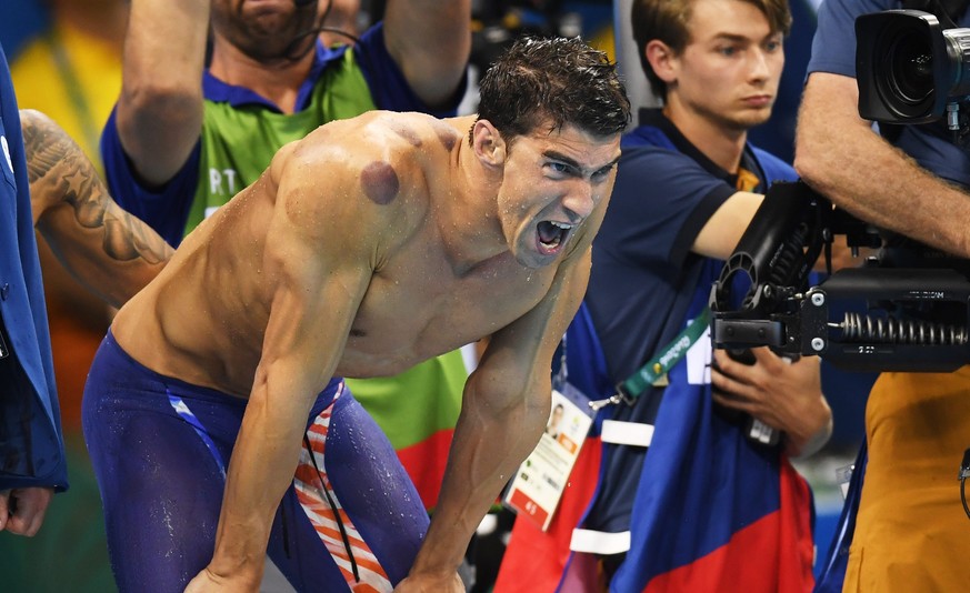 epa05463927 Michael Phelps of USA supports his teammates during the men&#039;s 4x100m Freestyle relay final race of the Rio 2016 Olympic Games Swimming events at Olympic Aquatics Stadium at the Olympi ...