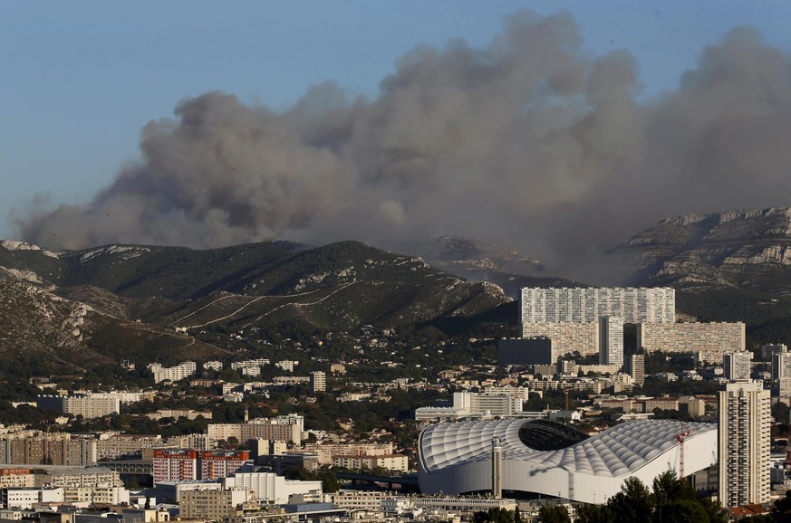 The Velodrome stadium in Marseille (front,R) is seen as smoke fills the sky during fires which burn the Calanques National Park, France, September 5, 2016. REUTERS/Jean-Paul Pelissier