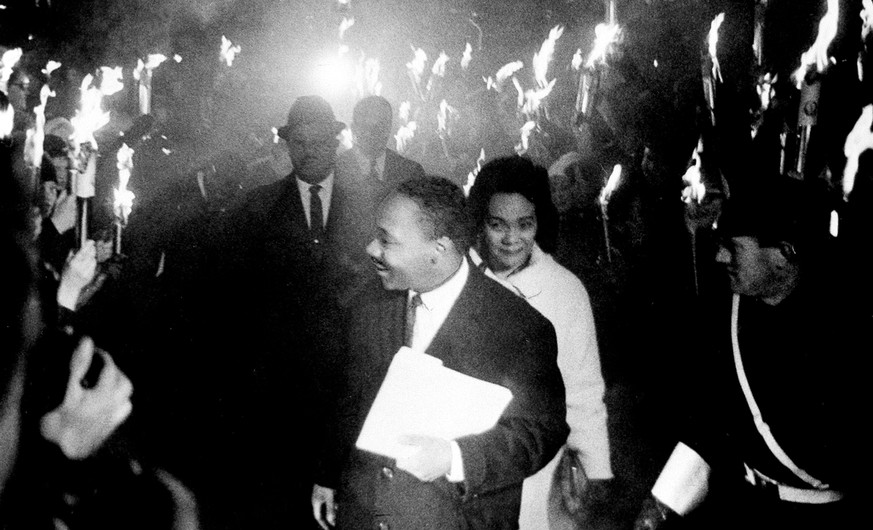 In this Dec. 10, 1964, file photo, through the smoke and fire from hundreds of torches, U.S. civil rights leader and Nobel Peace Prize winner, Dr. Martin Luther King Jr., arrives with his wife Coretta ...