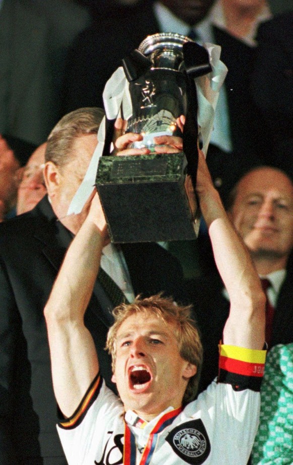 German team captain Jurgen Klinsmann raises the European Championship trophy after his team beat the Czech Republic 2-1 in extra-time in the final at Wembley Stadium in London in this June 30, 1996 pi ...