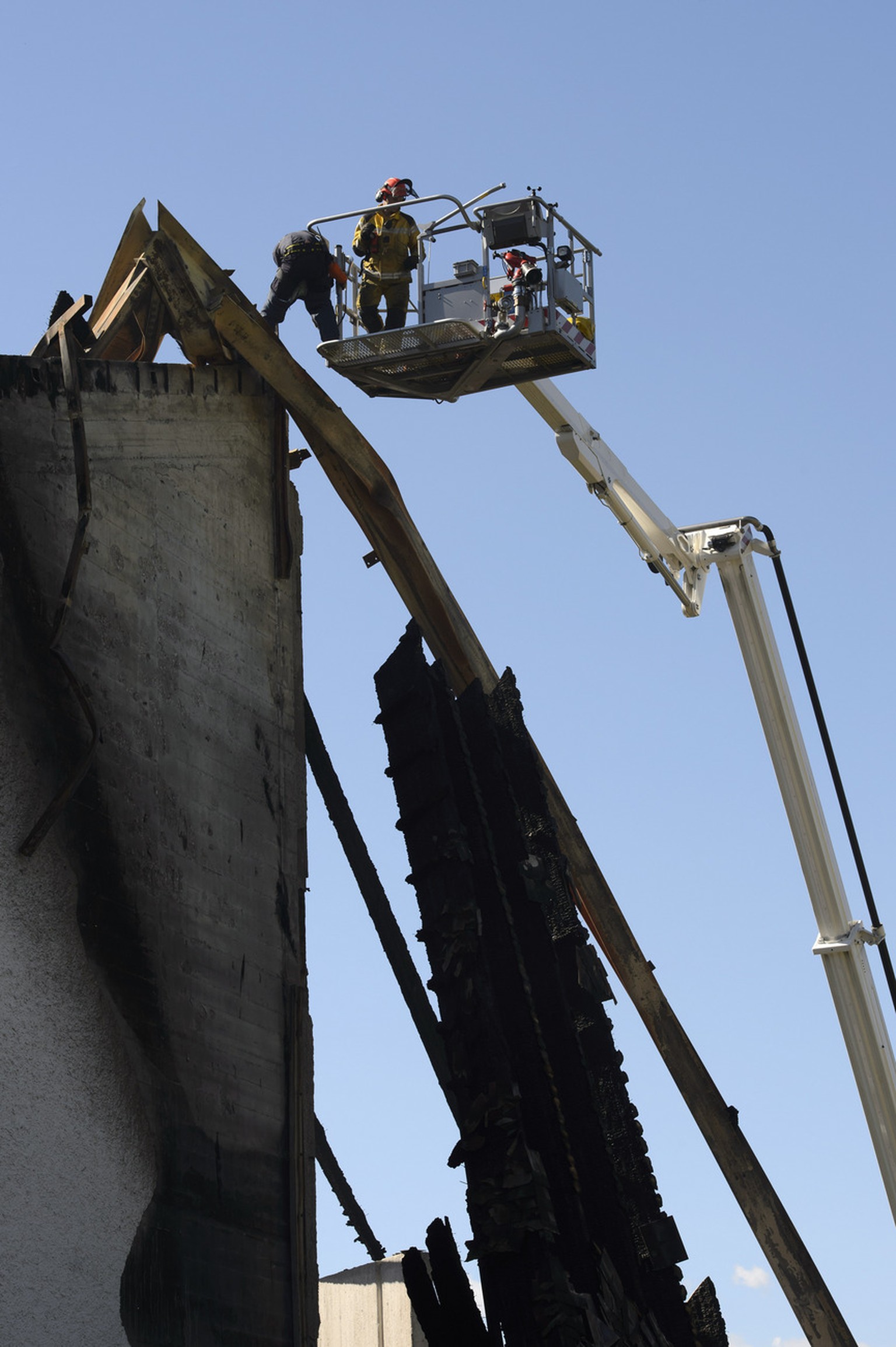 Gefährlich hängende Trümmerteile schneiden die Rettungskräfte ab.&nbsp;