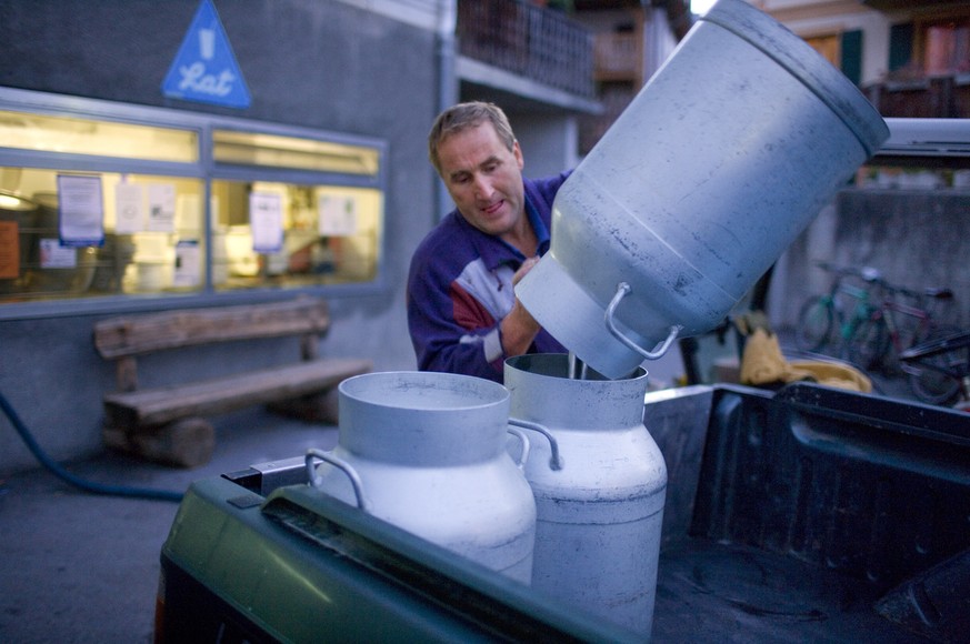 Ein Bauer leert vor der Molkerei in Sent im Engadin, Kanton Graubünden, Schweiz, seine Milchkannen um. Zwei Mal pro Jahr wird die Milch jedes Schweizer Milchproduzenten getestet.&nbsp;