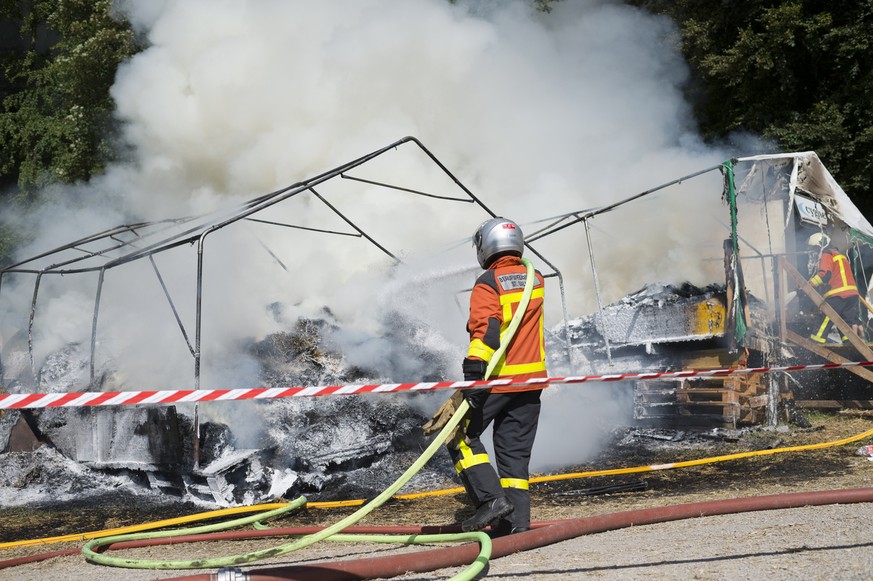 Firemen clear burning tents during the music festival Openair St. Gallen, on Sunday, June 28, 2015, in St. Gallen, Switzerland. The event runs until June 28. (KEYSTONE/Gian Ehrenzeller)