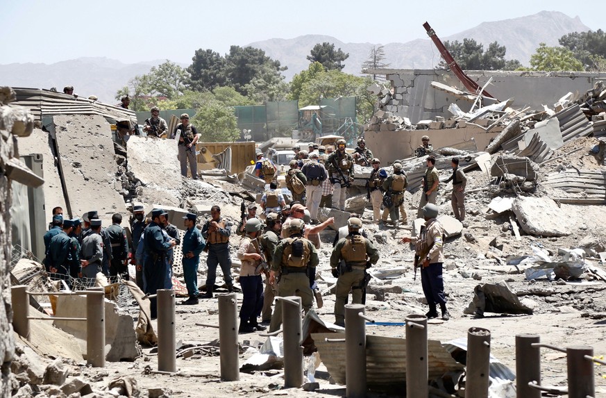 epaselect epa06000671 German and Afghan security officials inspect the scene of destruction caused by a suicide bomb attack at the German Embassy in Kabul, Afghanistan, 31 May 2017. At least 80 people ...
