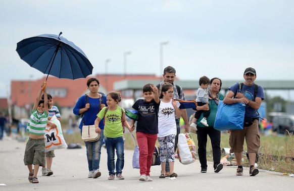 epa04914179 Refugees walk along a pathway at the border town of Nickelsdorf, Austria after arriving by bus from Hungary early 5 September 2015. The first of thousands of refugees reached Austria early ...