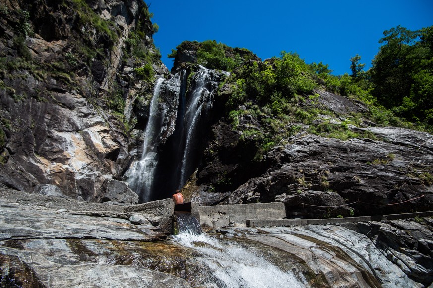 Ein Badender geniesst den Fluss vor dem Wasserfall &quot;del Salto&quot;, auch bekannt unter dem Namen &quot;Cascata Pozzaccio&quot; in Maggia im Maggiatal, am Sonntag, 17. Juli 2016. Das tessiner Mag ...