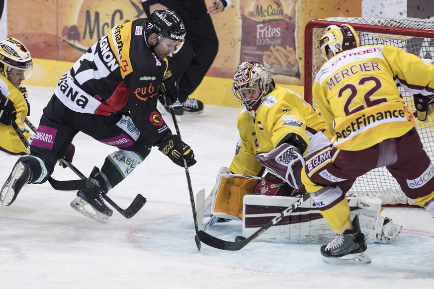 Berns Aaron Gagnon, links, im Duell gegen Genfs Goalie Robert Mayer, Mitte, und Jonathan Mercier im Eishockey National League A Spiel zwischen dem SC Bern und Geneve-Servette HC, am Freitag, 24. Febru ...