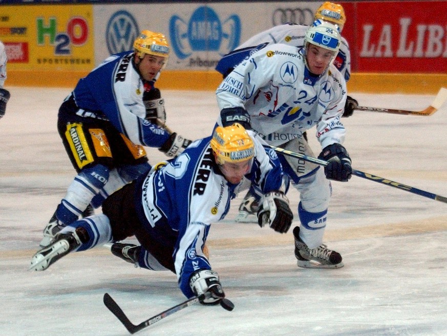 Silvan Luessy von Fribourg Gotteron, Mitte, im Kampf gegen Duri Camichel vom EV Zug, rechts, am Samstag, 24. November 2001 im Spiel HC-Fribourg Gotteron gegen EV Zug in Fribourg. (KEYSTONE/Juerg Muell ...