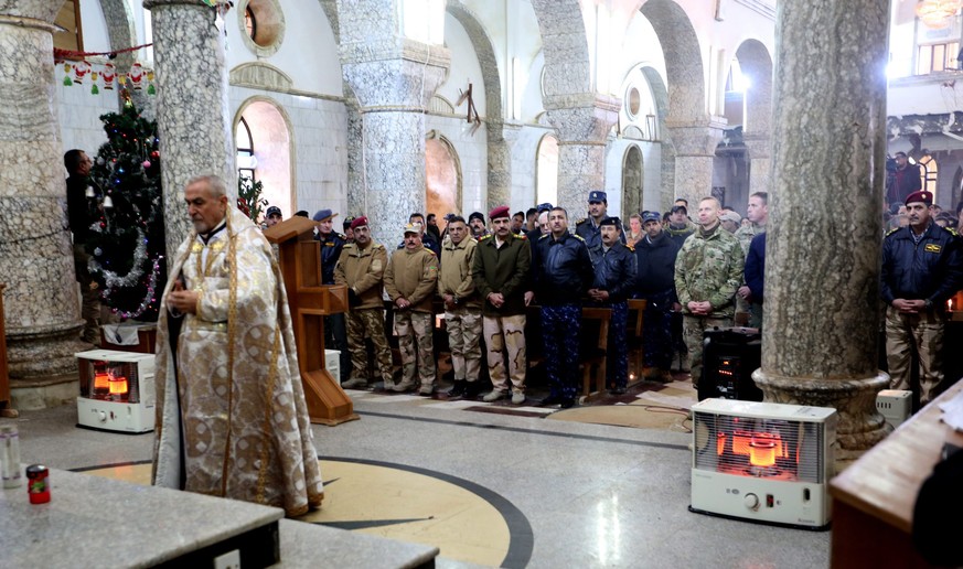 epa05688096 An Iraqi priest leads the prayers during a Christmas mass at the al-Tahira al-Kubra church in the formerly IS held town of al-Hamdaniya, some 13km east of Mosul, Iraq, 25 December 2016. Hu ...