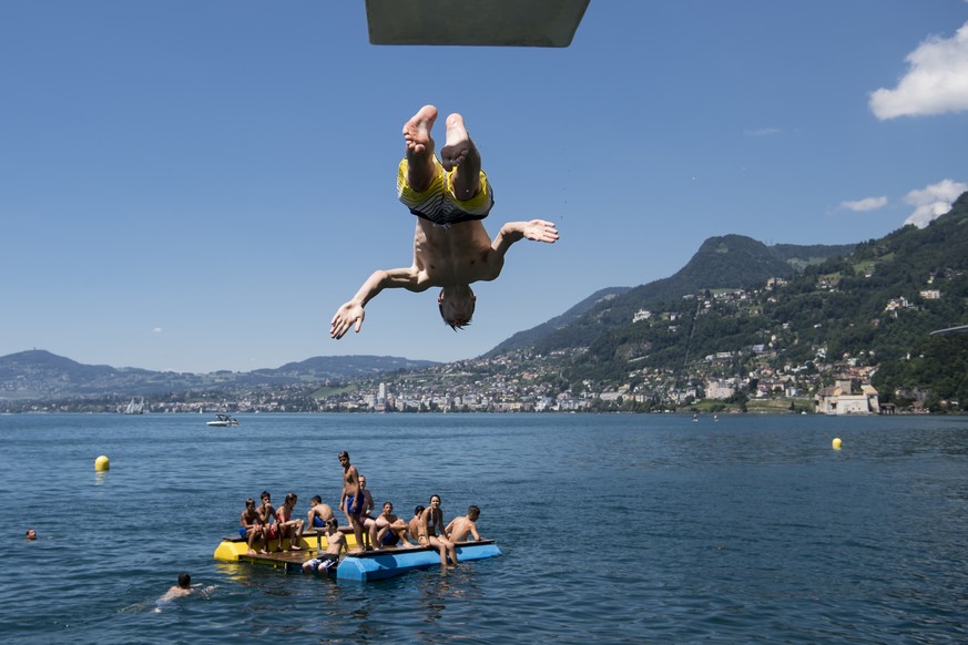 Kids jump from a diving platform into the Geneva Lake and enjoy sunny and warm weather, in Villeneuve, Southwestern Switzerland, Saturday, July 9, 2016. (KEYSTONE/Jean-Christophe Bott)