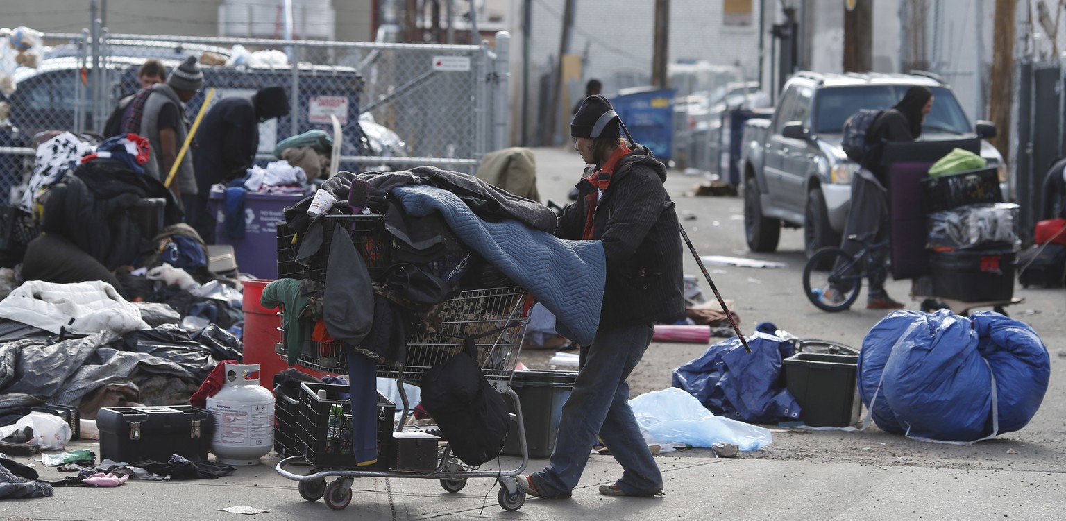 Homeless people clear their belongings of from a camp near the Denver Rescue Mission, Tuesday, March 8, 2016, in Denver. The city has spent months urging the campers to move into shelters and get rid  ...