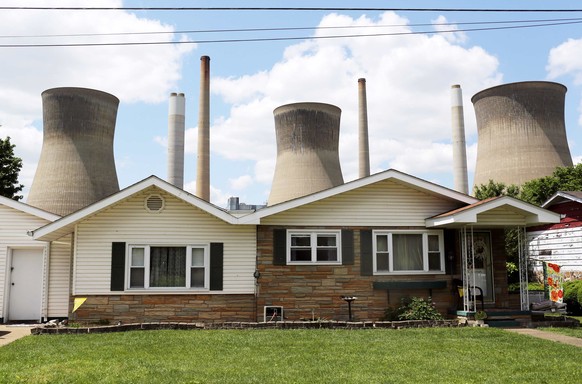 FILE PHOTO -- The John Amos coal-fired power plant is seen behind a home in Poca, West Virginia May 18, 2014. With coal production slowing due to stricter environmental controls, the availability of n ...