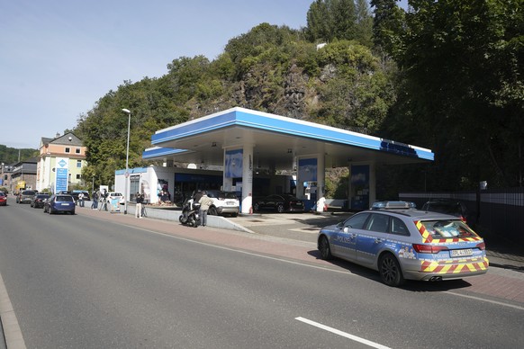 Media and a police car stand in front of a gas station in Idar-Oberstein, Germany, Tuesday, Sept. 21, 2021. Police in Germany say a 49-year-old man has been arrested on suspicion of murder in connecti ...