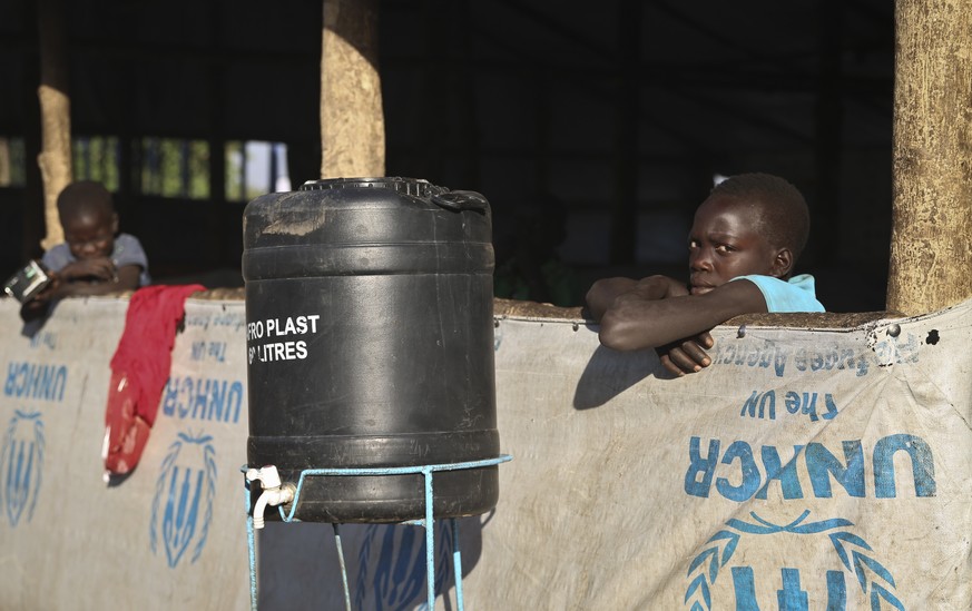 In this photo taken Thursday, Feb. 16, 2017, young South Sudanese refugee boys stand inside a shelter at a refugee collection center in Palorinya, Uganda. More than 100,000 people have fled a single c ...