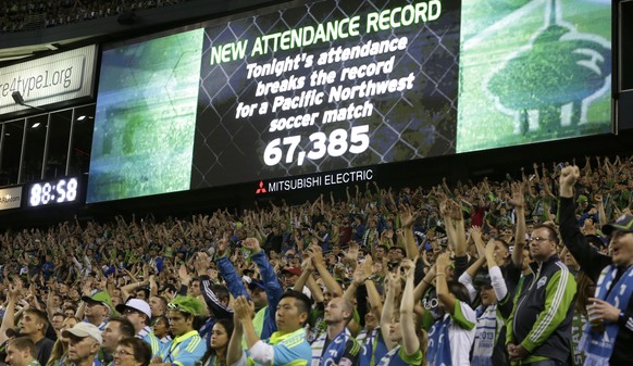 FILE - In this Aug. 25, 2013 file photo, fans cheer as a record-setting attendance of more than 67,000 is announced during a MLS soccer match between the Seattle Sounders and the Portland Timbers, in  ...