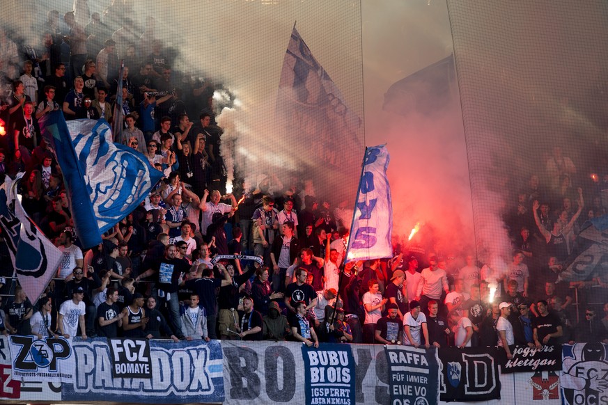 In this photo taken Sunday, April 12, 2015, fans of FC Zurich soccer Club burn torches during the soccer Championship Super League Game between FC Basel and FC Zurich at the St. Jakob-Park stadium in  ...