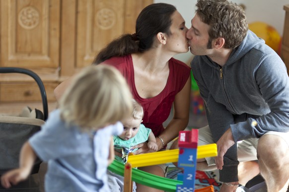 ZUR NEUSTEN UMFRAGE DES BUNDESAMTES FUER STATISTIK, UEBER DEN KINDERWUNSCH VON JUNGEN MAENNERN UND FRAUEN, STELLEN WIR IHNEN FOLGENDES ARCHIVBILD ZUR VERFUEGUNG - An unmarried couple kisses while thei ...