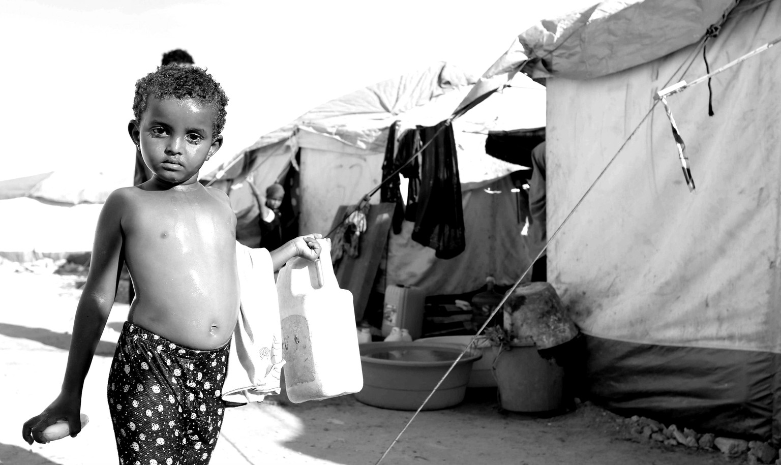 Somalia, Mogadischu, 2015: Ein jemenitischer Junge trägt einen Kanister durchs Flüchtlingscamp.