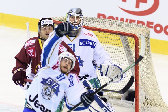 Le joueur zougois, Marc Marchon, centre, lutte pour le puck avec le joueur genevois, Juraj Simek, gauche, devant le gardien genevois, Robert Mayer, droite, lors du match de hockey sur glace de demi-fi ...