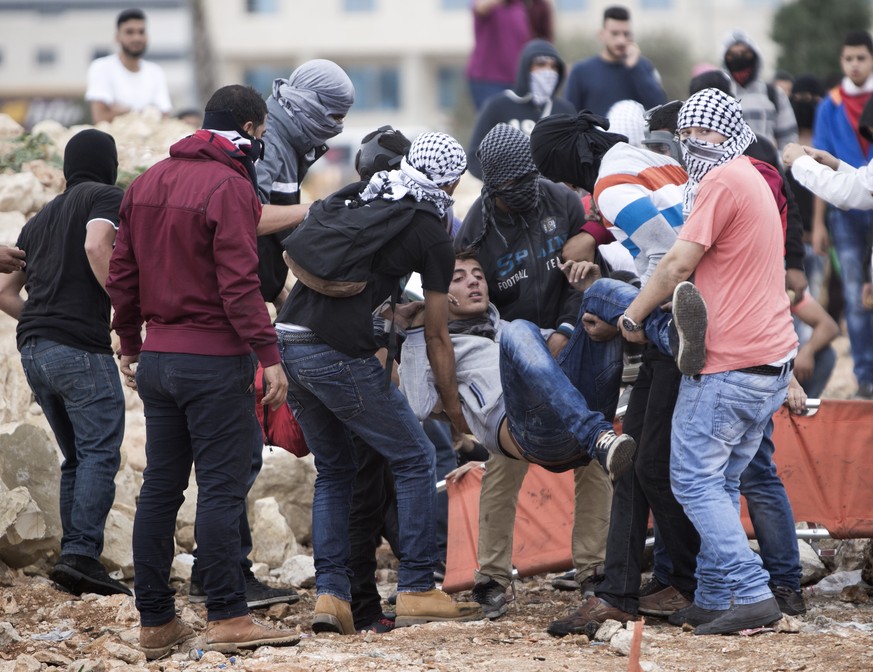 Palästinenser tragen einen Mann weg, der beim Zwischenfall angeschossen wurde.