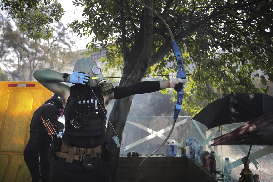 A protestor prepares to fire a bow and arrow during a confrontation with police at the Hong Kong Polytechnic University in Hong Kong, Sunday, Nov. 17, 2019. (AP Photo/Kin Cheung)
