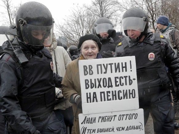 Policemen detain a participant of an unauthorised rally in St. Petersburg, Russia, Saturday, April 29, 2017. A poster reads &#039;Putin, you can retire!&#039;. A few dozens protesters were detained by ...