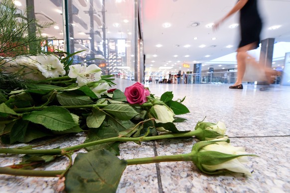 epa05441628 Flowers are seen on the ground in the Olympic shopping mall (OEZ) four days after a shooting that killed and injured people in Munich, Germany, 26 July 2016. According to authorities, at l ...
