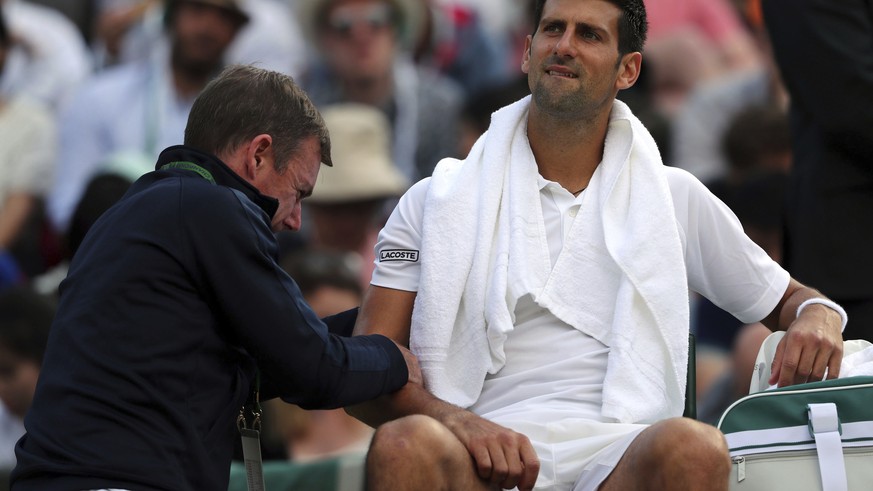 Serbia&#039;s Novak Djokovic receives medical treatment during his Men&#039;s Singles Match against Czech Republic&#039;s Tomas Berdych on day nine of the Wimbledon Tennis Championships at The All Eng ...