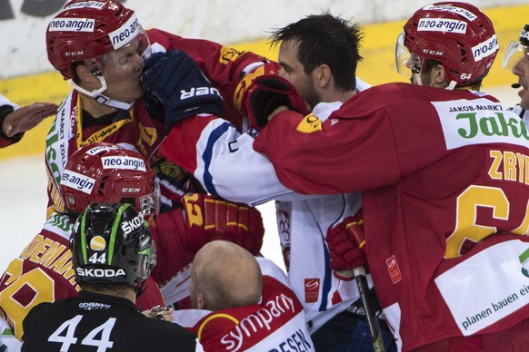 Tigers Ville Koistinen, links, und Miro Zryd, rechts, im Faustkampf gegen Lions Luca Cunti, Mitte, waehrend dem Eishockey National League A Spiel zwischen den SCL Tigers und den ZSC Lions, am Samstag, ...