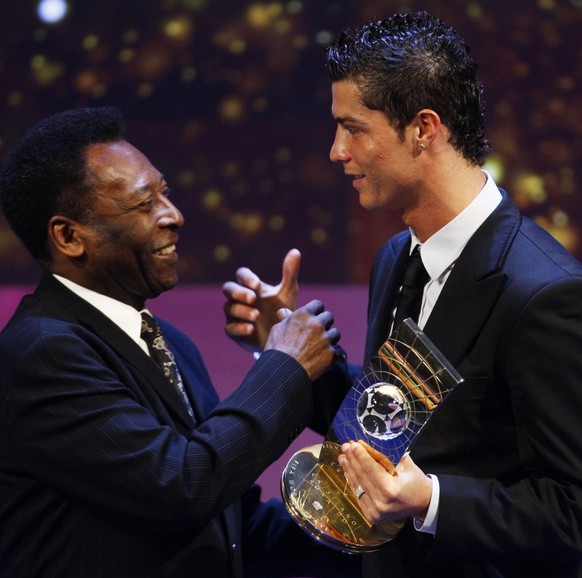 Soccer player Cristiano Ronaldo from Portugal, right, receives the trophy from former Brazilian soccer star Pele, left, after being named FIFA World Player of the Year during the FIFA World Player Gal ...