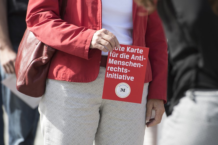 Anhaenger der NGO-Koalition &quot;Schutzfaktor M&quot;, zeigen die rote Karte an einer Aktion gegen die Selbstbestimmungsinitiative &quot;Schweizer Recht statt fremde Richter&quot; der SVP, am Freitag ...