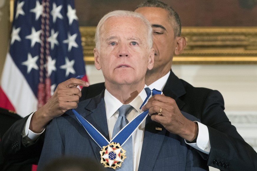 epa05713731 US President Barack Obama (Back) awards the Presidential Medal of Freedom to US Vice President Joe Biden (Front) in the State Dining Room of the White House, in Washington, DC, USA, 12 Jan ...