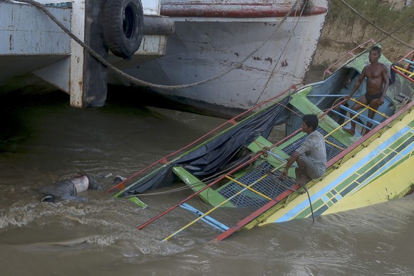 epa05590369 Local rescue workers sit on apart of a sunk ferry boat on the Chindwin river near the city of Monywa, Sagaing Division, Myanmar, 18 October 2016. Acoording to local sources, the death toll ...