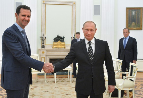 FILE - In this file photo taken on Tuesday, Oct. 20, 2015, Russian President Vladimir Putin, center, shakes hand with Syrian President Bashar Assad as Russian Foreign Minister Sergey Lavrov, right, lo ...