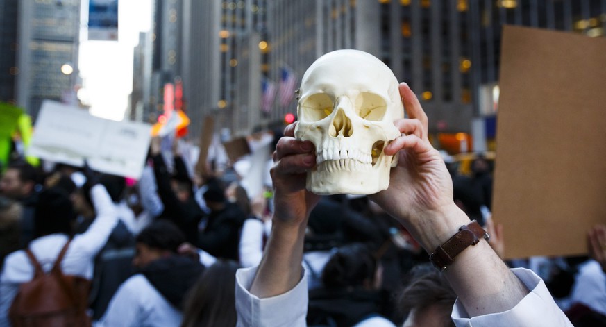 epa05762042 New York-area medical students, including one holding up a plastic human skull, gather to protest the proposed plan by the President Donald Trump and the Republican party leadership to rep ...