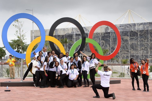 epa05453237 People pose for photos in front of Olympic Rings at the Barra Olympic Park, prior to the Rio 2016 Olympic Summer Games, in Rio de Janeiro, Brazil, 03 August 2016. EPA/LAURENT GILLIERON