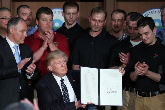 U.S. President Donald Trump holds up an executive order on &quot;Energy Independence,&quot; eliminating Obama-era climate change regulations, during a signing ceremony at the Environmental Protection  ...