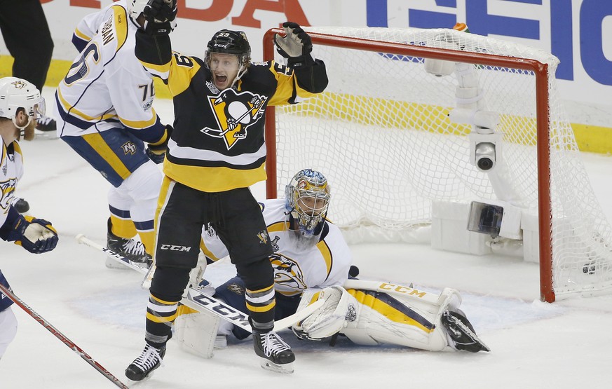 Pittsburgh Penguins&#039; Jake Guentzel, front, celebrates a goal by teammate Evgeni Malkin in front of Nashville Predators goalie Pekka Rinne during the first period in Game 1 of the NHL hockey Stanl ...