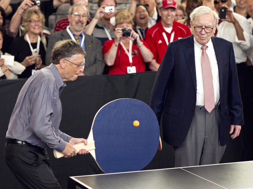 FILE - In this May 6, 2012 file photo, Warren Buffett, chairman and CEO of Berkshire Hathaway, right, watches Bill Gates use an oversize paddle as they play doubles against table tennis prodigy Ariel  ...