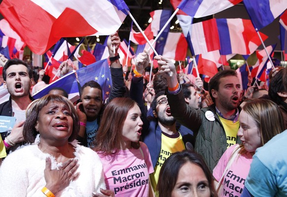 epa05924271 Supporters celebrate as French presidential election candidate for the &#039;En Marche!&#039; (Onwards!) political movement, Emmanuel Macron (not in picture) finishes in first position of  ...