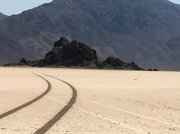 This Aug. 26, 2016 photo provided by the National Park Service shows fresh curved tire tracks illegally made by a vehicle, crossing earlier illegal tracks, on the Racetrack Playa at Death Valley Natio ...