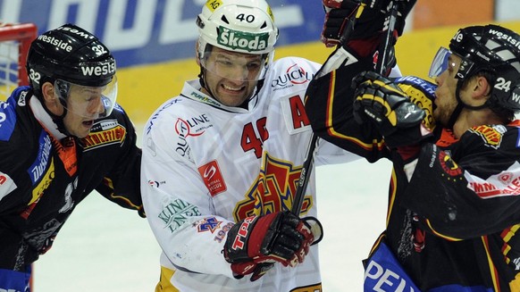 Die Berner Ivo Ruethemann, links, und Caryl Neuenschwander, rechts, nehmen den Bieler Martin Steinegger, Mitte, ins Sandwich beim Eishockey Meisterschaftsspiel der National League A zwischen dem SC Be ...