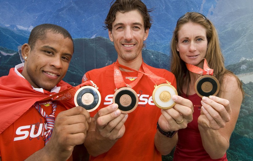 Die Schweizer Athleten Karin Thuerig, Fabian Cancellara und Sergei Aschwanden, von rechts, praesentieren ihre Medaillen am Donnerstag, 14. August 2008, im Olympic Village in Peking. (KEYSTONE/Alessand ...