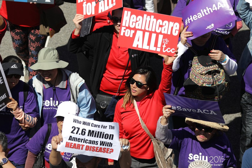 People march in a &quot;Save Obamacare&quot; rally on the seventh anniversary of Obamacare&#039;s signing, in Los Angeles, California, U.S. March 23, 2017. REUTERS/Lucy Nicholson