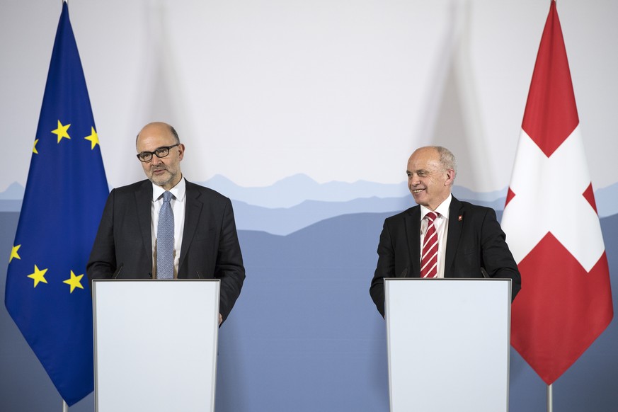 Swiss Federal Councillor Ueli Maurer, right, and Pierre Moscovici, European Commissioner for Economic and Financial Affairs, left, speak during a press briefing in the federal parliament building, Tue ...