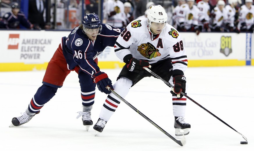 Chicago Blackhawks&#039; Patrick Kane, right, keeps the puck away from Columbus Blue Jackets&#039; Dean Kukan during the first period of an NHL hockey game Saturday, April 9, 2016, in Columbus, Ohio.  ...